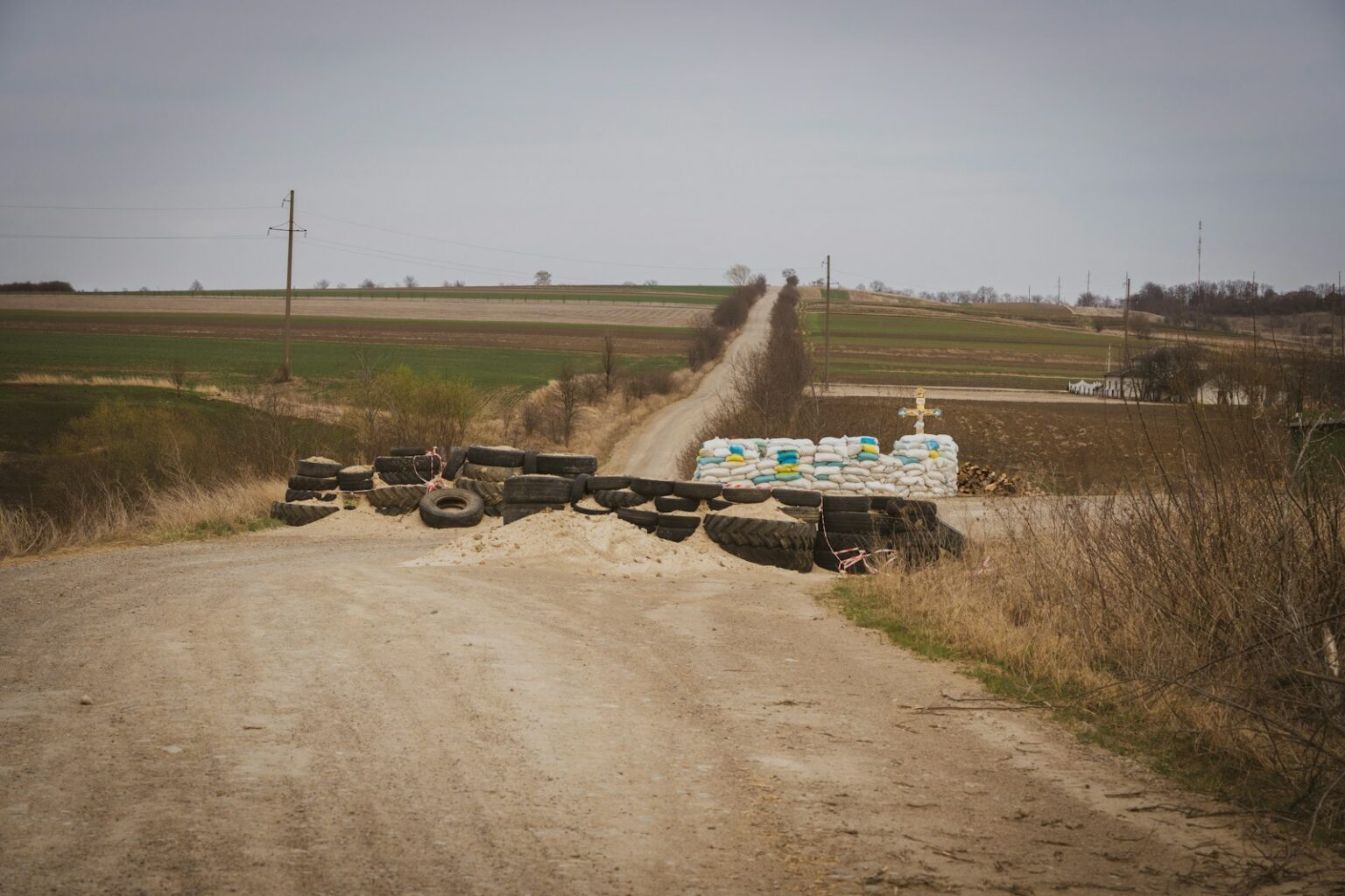 a pile of tires sitting on the side of a dirt road