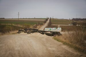 a pile of tires sitting on the side of a dirt road